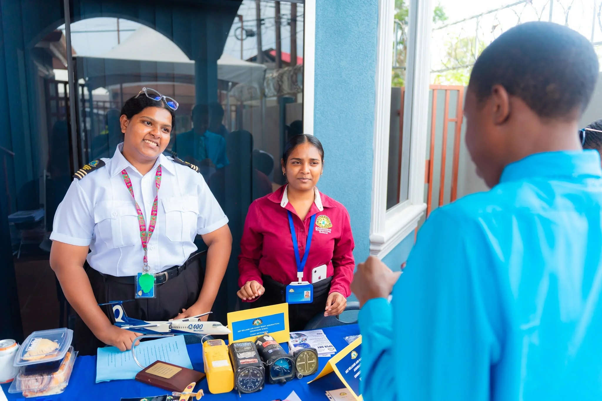 A student speaking with visitors at an aviation information table