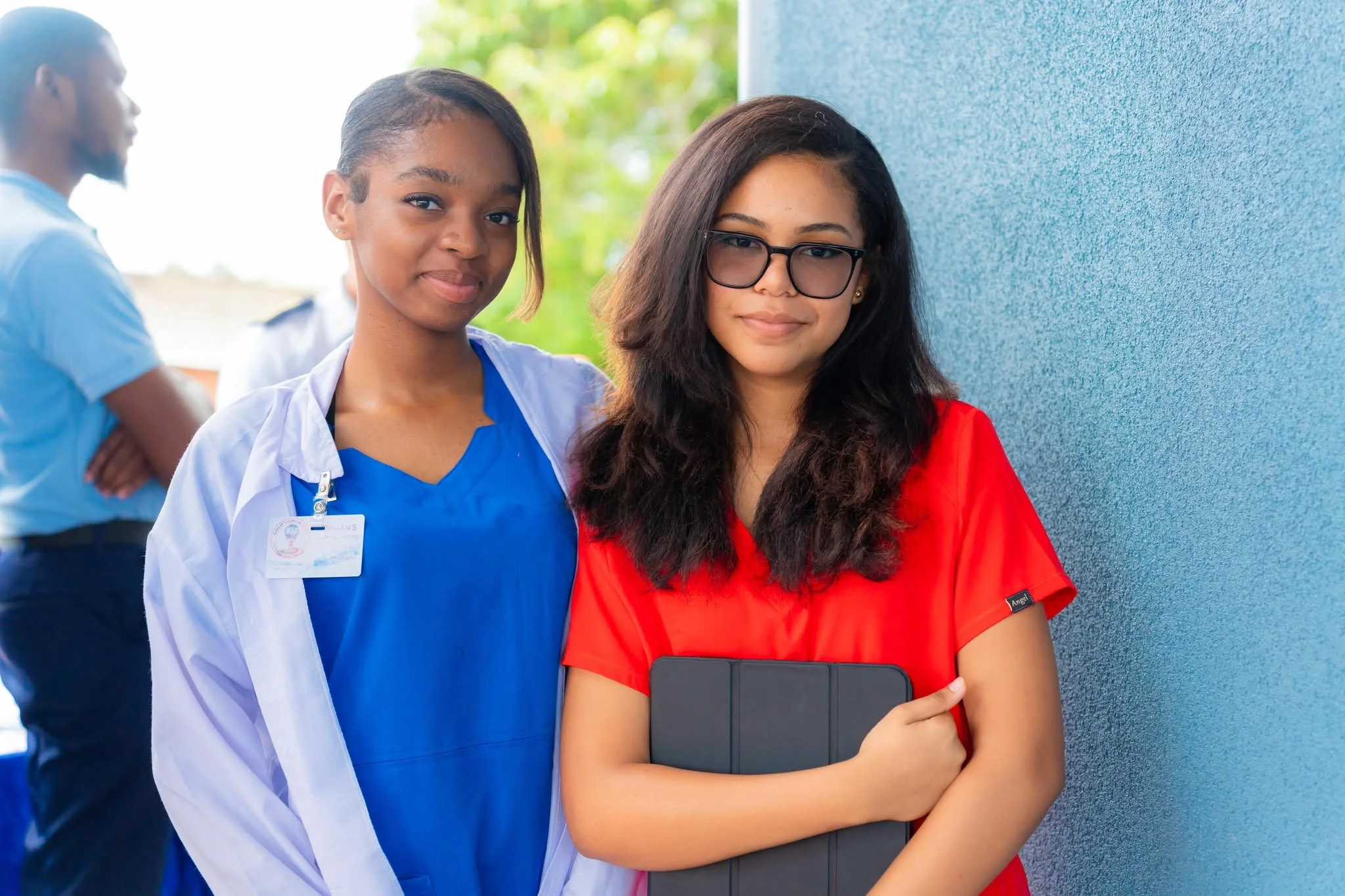 Two students at school, one wearing a white coat over blue clothing